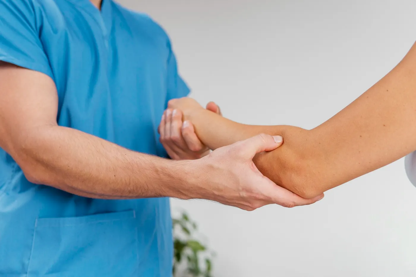 A chiropractor examining a patient's elbow and forearm